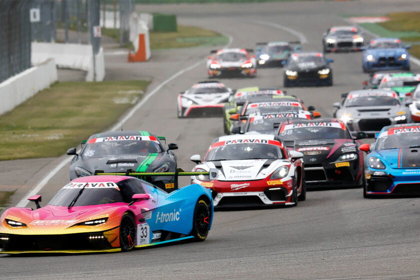 Several cars drive on a race track.