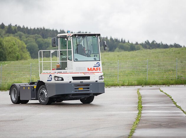 An autonomously driving terminal tractor from MAFI, converted with NX NextMotion, moves driverless across a training area.