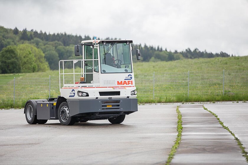 An autonomously driving terminal tractor from MAFI, converted with NX NextMotion, moves driverless across a training area.