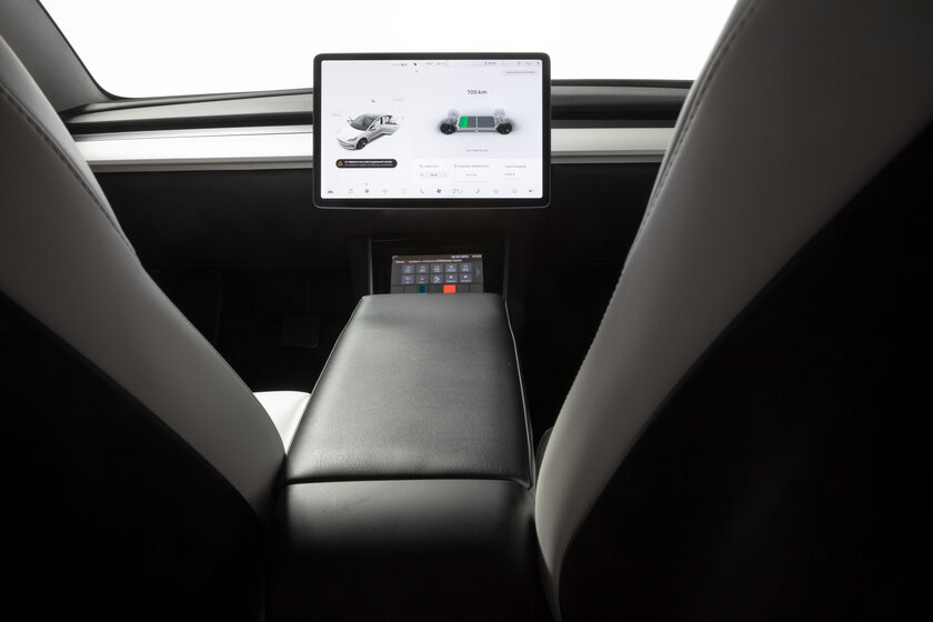 Looking forward from the back seat of a car toward the cockpit, you see a large touchscreen display in the middle, but no steering wheel.  