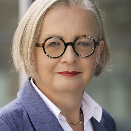 A friendly smiling woman with glasses who is Anke Leuschke and is your contact person.