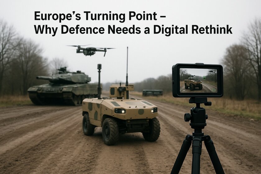 Several military vehicles are standing on a web of earth in the middle of nature. A kind of photo/film camera records the whole thing from the front.