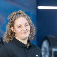 A young woman with a friendly smile and medium-length, curly blonde hair.