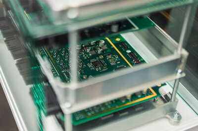A green circuit board that is displayed behind a glass pane and belongs to the NX NextMotion.