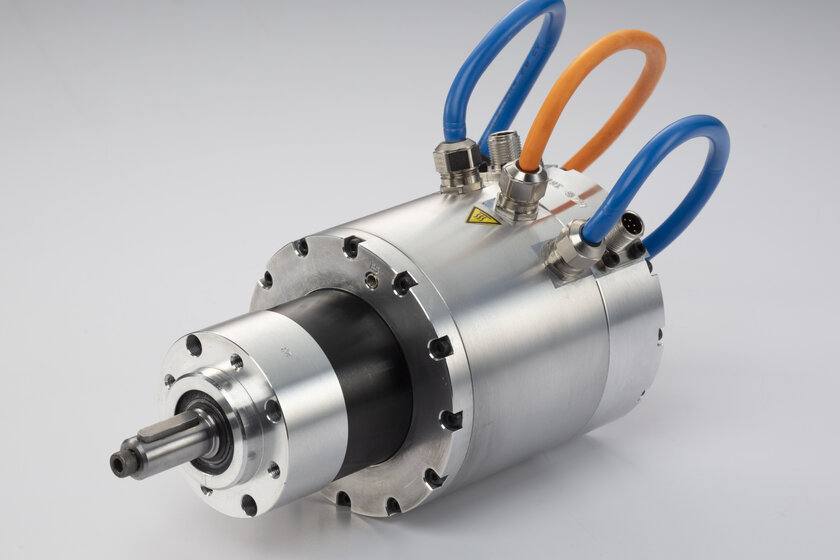 A road wheel actuator (motor) lies on a white table.