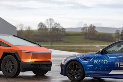Two cars stand face to face. The one in the back is an orange Cybertruck, the one in front a blue branded BMW from Arnold NextG.