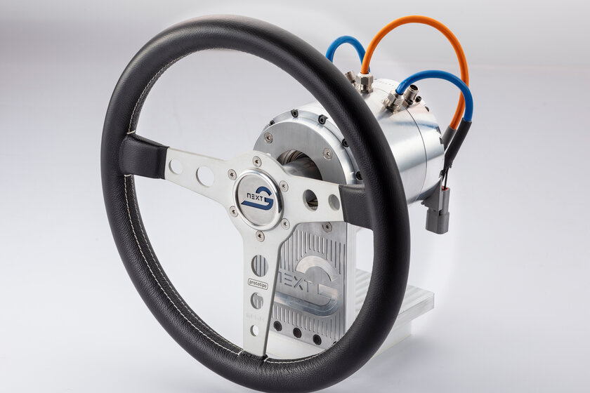 A steering wheel with a steering gear is standing in a white room.