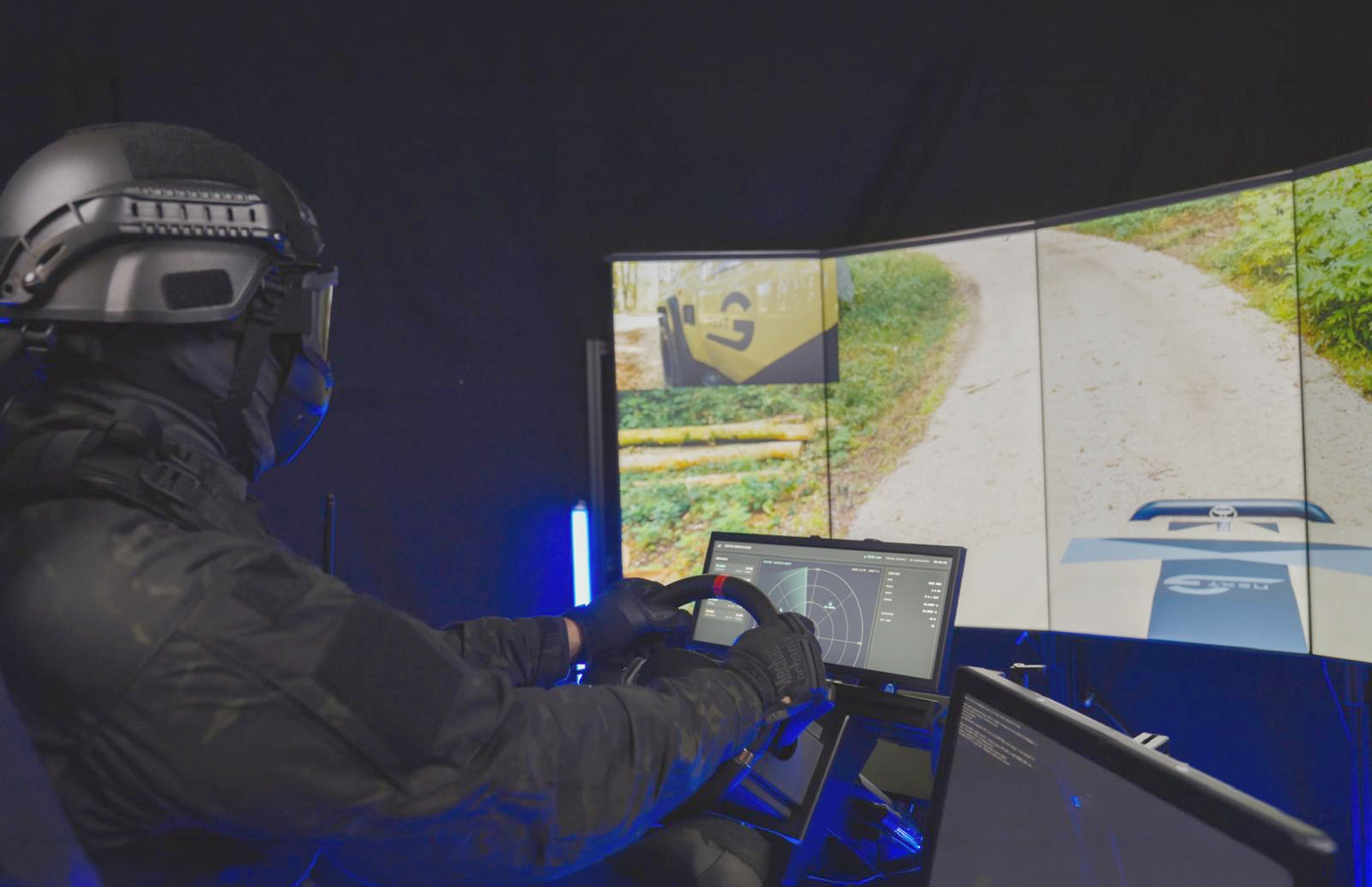 Remote operator controlling an autonomous wheeled vehicle in off-road terrain via a teleoperation system.