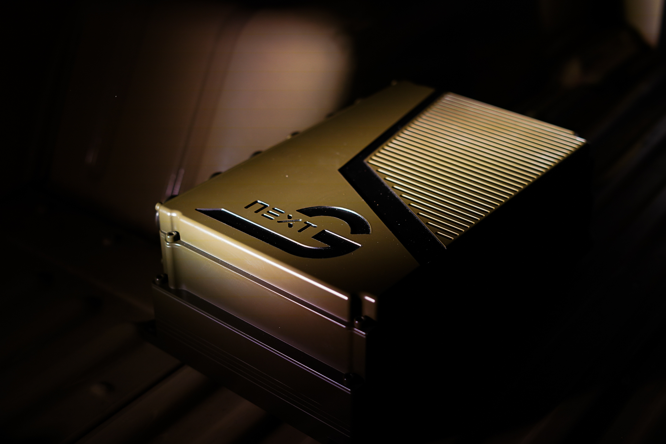 An NX NextMotion control unit in dark green. Only the NX NextMotion is illuminated in yellow; everything around it is black.